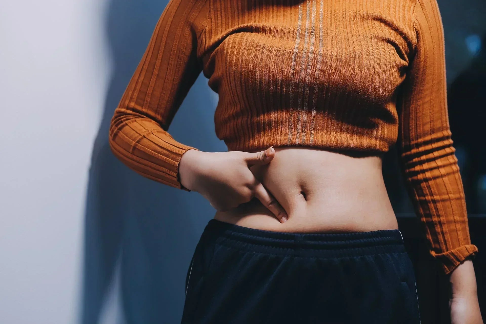 Een persoon die zijn buik aanraakt terwijl ze het proces van spijsvertering ervaren.