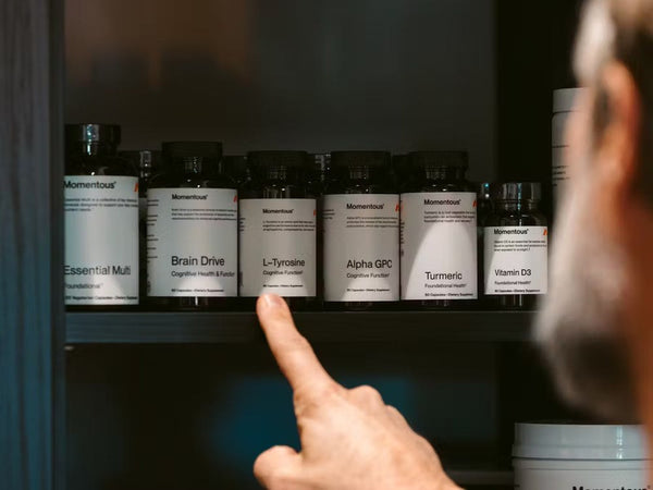 Man die een pot Momentous pakt uit een kast vol supplementen