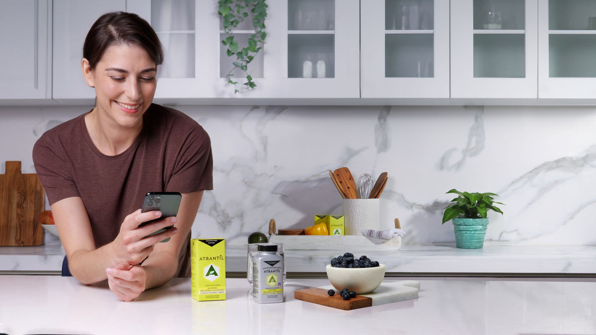 Vrouw in de keuken met Atrantil-supplementen op het aanrecht